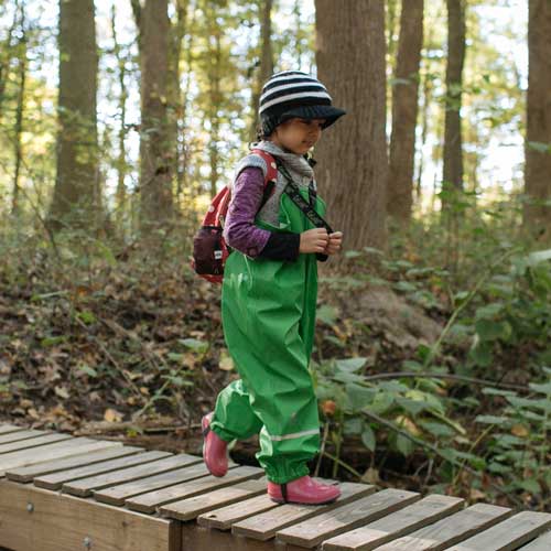 preschool girl walking in the woods